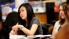 FILE - Sally Kim takes notes during a physics class at Columbia Independent School in Columbia, Mo., Feb. 27, 2012. Kim's parents, who live in South Korea, sent her to live with relatives in Columbia for a better education that provides more collegiate op