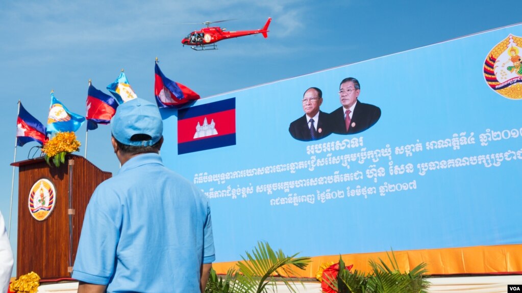រូបឯកសារ៖ រូបភាពឧទ្ធម្ភាចក្រពណ៍ក្រហម ដែលមានបិទស្លាកសញ្ញារបស់គណបក្សប្រជាជនកម្ពុជា ហោះឆ្វែល ជុំវិញក្បួនដង្ហែគណបក្សប្រជាជនកម្ពុជាដើម្បីថតយករូបភាពនៃក្បួនដង្ហែនេះ នៅភ្នំពេញថ្ងៃទី ០២ ខែមិថុនា ឆ្នាំ២០១៧។ (ខាន់ សុគុំមនោ/ VOA)