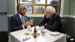 The Rev. Al Sharpton (l) talks with Democratic presidential candidate Sen. Bernie Sanders, as they sit down for a breakfast meeting at Sylvia's Restaurant, Feb. 10, 2016, in the Harlem neighborhood of New York. 