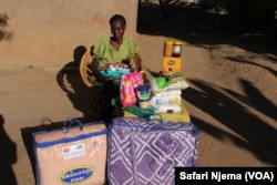 Anna Lungisani of Petworth, poses with donated gifts of groceries, blankets and clothes