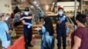 Petugas keamanan memeriksa suhu pengunjung pasar, sambil menjaga jarak sosial, di Penang, Malaysia di tengah pandemi Covid-19, 29 Mei 2020. (Foto: GOH Chai Hin / AFP)
