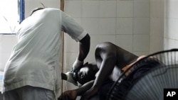 A man receiving treatment at a health clinic after being shot in the hip by security forces loyal to Laurent Gbagbo in the Anyama suburb of Abidjan, March 12, 2011
