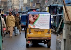 Iklan kampanye vaksinasi polio di sebuah bemo, melewati sebuah pasar di Peshawar, Pakistan. (Foto: dok).