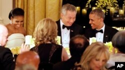President Barack Obama, right, and Singapore's Prime Minister Lee Hsien Loong, talk after toasting each other during a state dinner at the White House in Washington, D.C., Aug. 2, 2016. At left is first lady Michelle Obama.