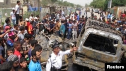 Residents gather at the site of a car bomb attack in Baghdad's Sadr City, May 16, 2013.