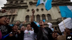 Demonstrators wave Guatemalan flags as they celebrate that Congress voted to withdraw President Otto Perez Molina's immunity from prosecution, in Guatemala City, Tuesday, Sep. 1, 2015.