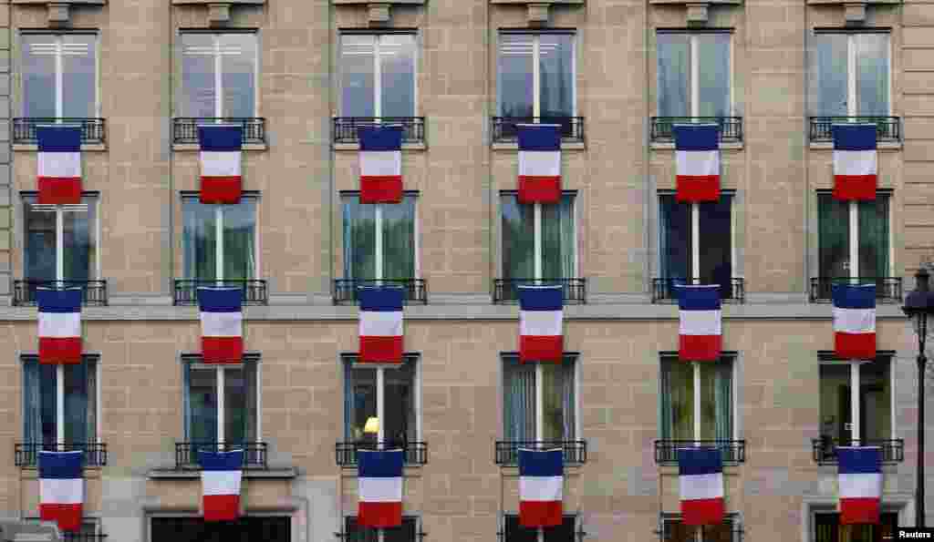 Bendera Perancis digantung dari jendela sebuah gedung dekat kompleks Invalides di Paris setelah Presiden Hollande menyerukan agar semua warga menggantung bendera nasional mereka yang berwarna merah, putih, biru dari jendela untuk menghormati korban serangan maut di Paris pada upacara pemakaman nasional hari Jumat.