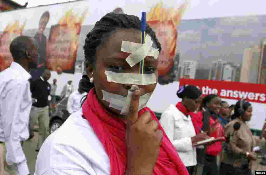 A Kenyan journalist participates in a protest with tape over her mouth and a pen on her forehead along the streets of the capital Nairobi. Members of the media marched in a peaceful protest to denounce the new draconian laws tabled by parliament.