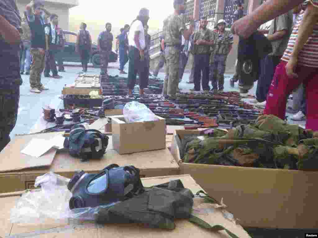 Members of the Free Syrian Army stand near weapons they say were gained from forces loyal to Syria's President Bashar al-Assad, in Aleppo July 25, 2012.