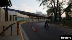Un policía pasa en bicicleta después que el presidente de El Salvador, Nayib Bukele, ordenó el cierre del aeropuerto para evitar la diseminación del coronavirus en el Aeropuerto Internacional San Oscar Romero de San Salvador.