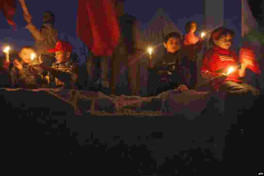 Palestinian children hold candles during a demonstration organized by the Popular Front for the Liberation of Palestine (PFLP), marking the 2nd anniversary of the Israel-Gaza war, in the Jebaliya refugee camp, northern Gaza Strip, Monday, Dec. 27, 2010. I