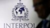 FILE - A man passes an Interpol logo in Singapore.