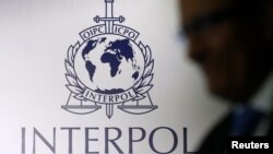 FILE - A man passes an Interpol logo in Singapore.
