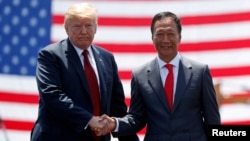 FILE - U.S. President Donald Trump shakes hands with Foxconn Chairman Terry Gou during a groundbreaking at Foxconn's new site in Mount Pleasant, Wis., June 28, 2018.