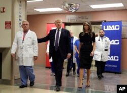 FILE - President Donald Trump and first lady Melania Trump walk with surgeon Dr. John Fildes at the University Medical Center after meeting with victims of the mass shooting in Las Vegas, Oct. 4, 2017.