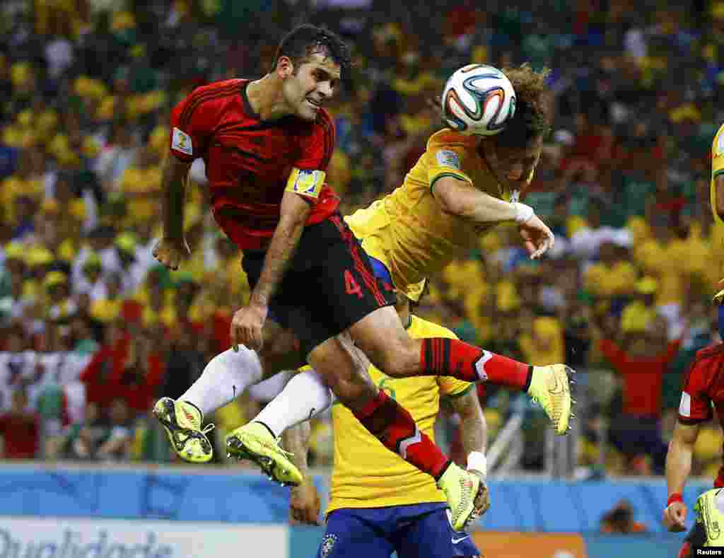 Pemain Meksiko Rafael Marquez (kiri) memperebutkan bola dengan pemain Brazil David Luiz di pertandingan grup A Piala Dunia 2014 di arena Castelao arena, di Fortaleza, 17 Juni 2014.