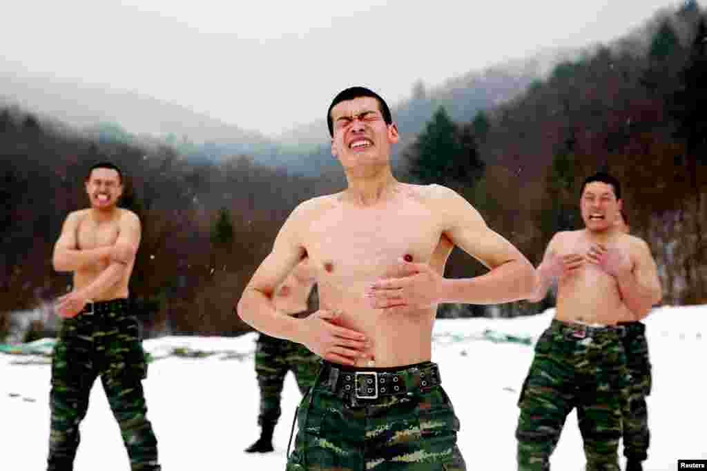 Paramilitary soldiers put snow onto their bodies during a winter training session at a snowfield in Changchun, Jilin province, China, Nov. 28, 2017.