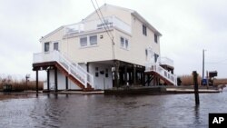 FILE - This March 14, 2017, photo shows Jim and Maryann O'Neill's home in a back bay neighborhood of Manahawkin, N.J., surrounded by water after a moderate storm.