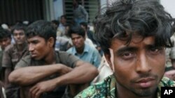 A group of rescued 129 Burma refugees belonging to the Muslim Rohingya minority sits sheltered at the port area in the village of Kreung Raya in Aceh province, February 16, 2011