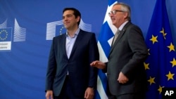European Commission President Jean-Claude Juncker, right, speaks with Greek Prime Minister Alexis Tsipras as they arrive for a meeting at EU headquarters in Brussels, Belgium, June 3, 2015.