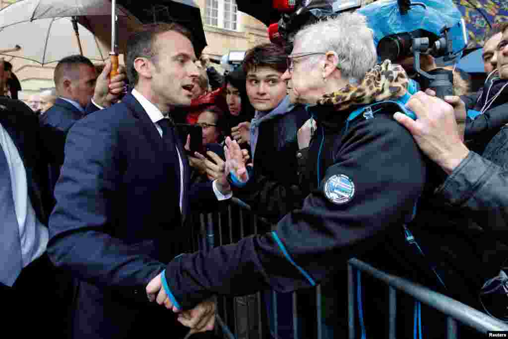 French President Emmanuel Macron talks with a resident at the city hall in Charleville-Mezieres, Eastern France, as part of a World War I commemoration tour.