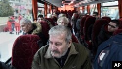 Residents of Kordelio district are taken away by bus after authorities ordered the area evacuated in order to defuse a 500-pound unexploded World War II bomb, in Thessaloniki, Greece, Feb. 12, 2017.