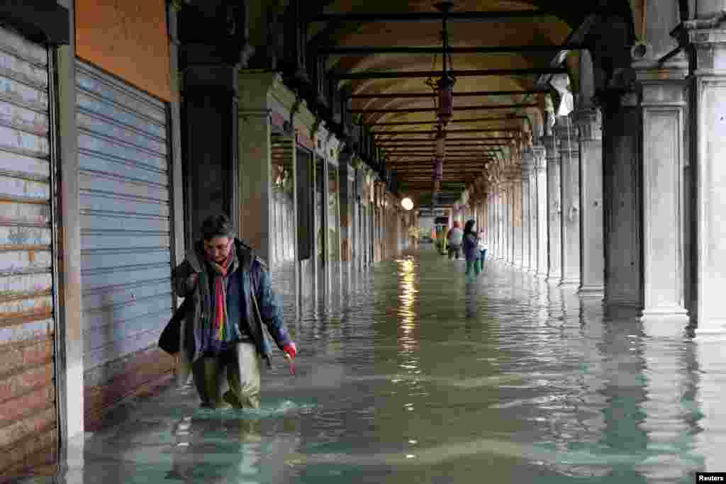 A woman walks in the flooded St. Mark&#39;s Square during a period of seasonal high water in Venice, Italy.