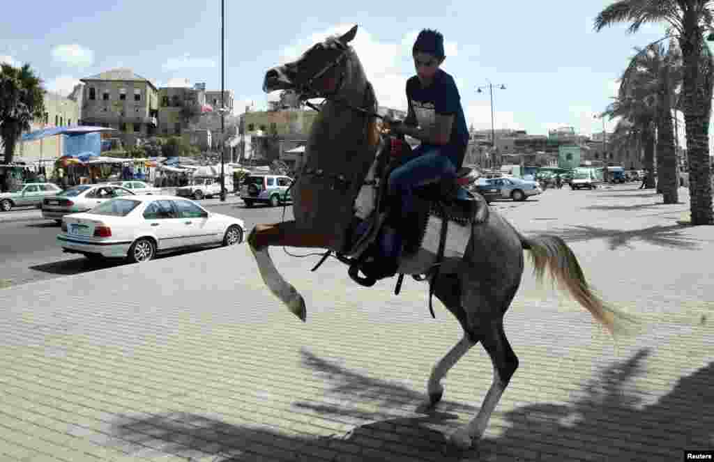 A youth rides a rented horse as he celebrates Eid al-Fitr in the port city of Sidon, southern Lebanon, August 8, 2013.&nbsp;