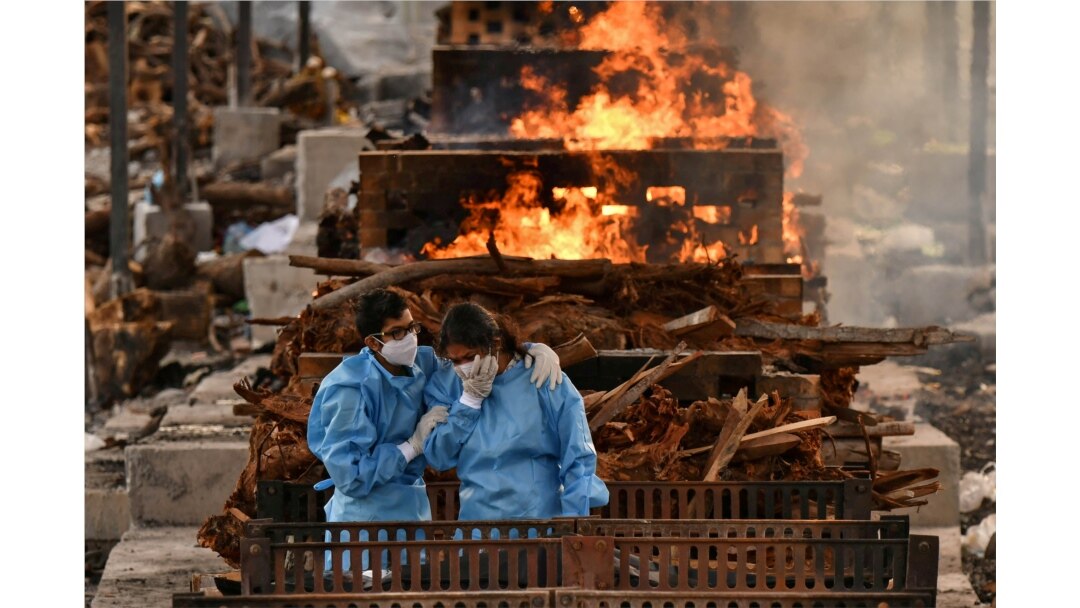 Kerabat pasien COVID-19 yang meninggal di sebuah krematorium di Desa Giddenahalli di pinggiran Bengaluru, India, 13 Mei 2021. (Foto: Samuel Rajkumar/Reuters)