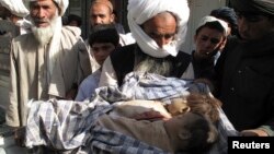 Man holds bodies of two children killed in counter-insurgency airstrike called in by US-NATO led troops, Helmand, Afghanistan, May 29, 2011.