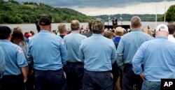 A coal barge is visible behind President Donald Trump as he speaks about infrastructure at Rivertowne Marina in Cincinnati, Ohio, June 7, 2017.