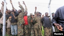 FILE - Congolese M23 rebel fighters gather inside an enclosure after surrendering to Uganda's government at Rugwerero village in Kisoro district, about 490 km west of Kampala, Nov. 8, 2013. 