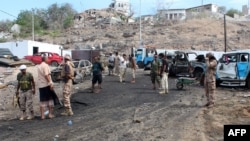 Yemeni loyalist forces and onlookers gather at the scene of a suicide attack targeting the police chief in the base of the Saudi-backed government on April 28, 2016 in Yemen's second city Aden.