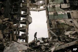 Seorang warga mencari barang-barang di gedung apartemen yang hancur saat pertempuran antara pasukan Ukraina dan Rusia di Borodyanka, Ukraina, Selasa, 5 April 2022. (Foto: AP/Vadim Ghirda)