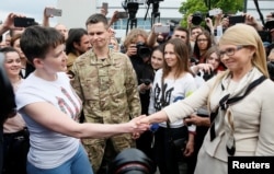 FILE - Ukrainian pilot Nadiya Savchenko, left, shakes hands with Fatherland party leader Yulia Tymoshenko at Boryspil International Airport outside Kyiv, Ukraine, May 25, 2016.