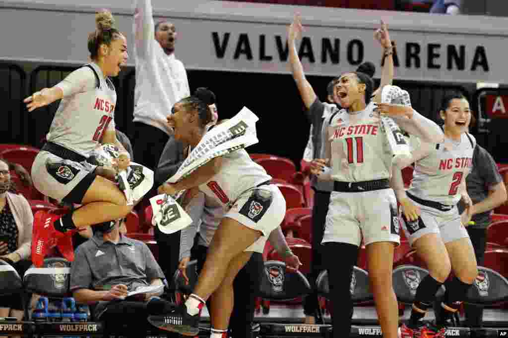 North Carolina State&#39;s Madison Hayes (21), Diamond Johnson (0), Jakia Brown-Turner (11) and Raina Perez (2) celebrate their win over Towson in an NCAA college basketball game, Nov. 15, 2021, in Raleigh, North Carolina.