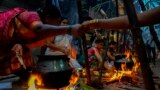 Tamil women greet each other as they cook special food to celebrate the harvest festival of Pongal at Dharavi, one of the Asia&#39;s largest slums, in Mumbai, India.
