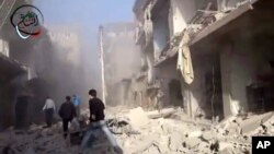 In this photo taken from video obtained from the Shaam News Network, Syrian men run to aid injured people in the aftermath of a strike by Syrian government warplanes on a neighborhood south of Damascus, Monday, Jan. 14, 2013.