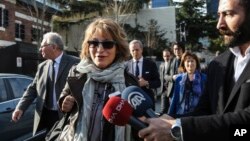 United Nations Special Rapporteur Agnes Callamard, surrounded by members of the media walks around the Saudi Consulate, background, in Istanbul, Turkey, Jan. 29, 2019. 