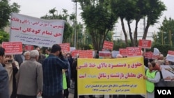 Dozens of Iranian education activists stage a protest outside the government's planning and budget office in Tehran, May 10, 2018. The protesters held signs calling for teachers to be paid at least more than Iran’s minimum wage (yellow sign, right) and for education to remain free for all Iranians (white sign, left). (Activist photo sent to VOA Persian) 