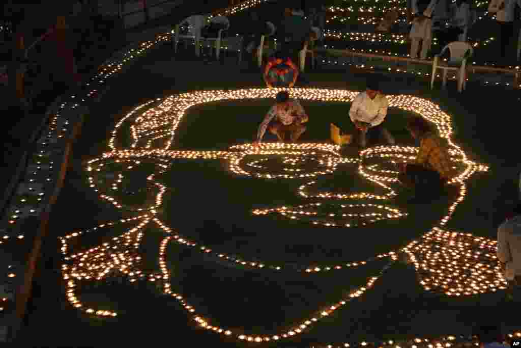 Indians makes formation of Bhim Rao Ambedkar with earthen lamps to mark Ambedkar&#39;s death anniversary in Ahmadabad. Ambedkar was one of the country&#39;s prominent freedom fighters and the chief architect of the Indian Constitution that outlawed discrimination based on caste.