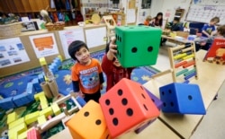 FILE - In this photo taken Friday, Feb. 12, 2016, Daniel O'Donnell, left, looks on as William Hayden sends large blocks flying at the Creative Kids Learning Center, a school that focuses on pre-kindergarten in Seattle. (AP Photo/Elaine Thompson)