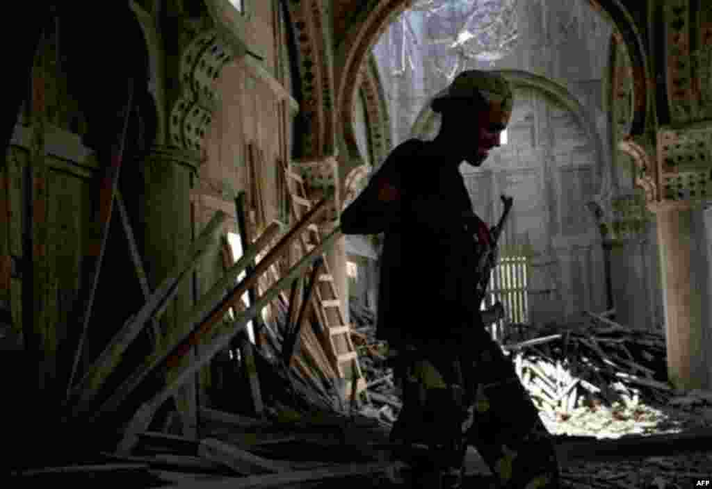 RETRANSMISSION TO ADD BYLINE - In this Wednesday, Aug. 17, 2011 photo, a Libyan rebel fighter enters an incomplete mosque that has been used as shelter during the shelling from Moammar Gadhafi's forces in Sabratha, 50 miles (75 kilometers) west of Tripoli