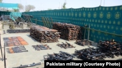 FILE - An undated photo shows weapons, ammunition, explosives and communication equipment found by Pakistani troops during a reaid on suspected militant hidouts in North Waziristan.
