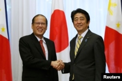 Tổng thống Benigno Aquino bắt tay Thủ tướng Nhật Bản Shinzo Abe (phải) trước cuộc họp ở Toyko, 24/6/2014