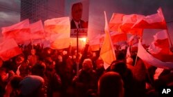 Demonstrators burn flares and wave Polish flags during the annual march to commemorate Poland's National Independence Day in Warsaw, Poland, Nov. 11, 2017. Thousands of nationalists marched in Warsaw on Poland's Independence Day holiday, taking part in an event that was organized by far-right groups.