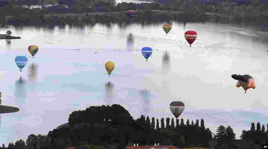 Hot air balloons float over Lake Burley Griffin during the Balloon Spectacular in Canberra, Australia.