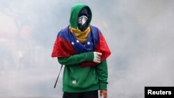 A demonstrator clashes with riot police while rallying against Venezuela's President Nicolas Maduro in Caracas, Venezuela, April 13, 2017.