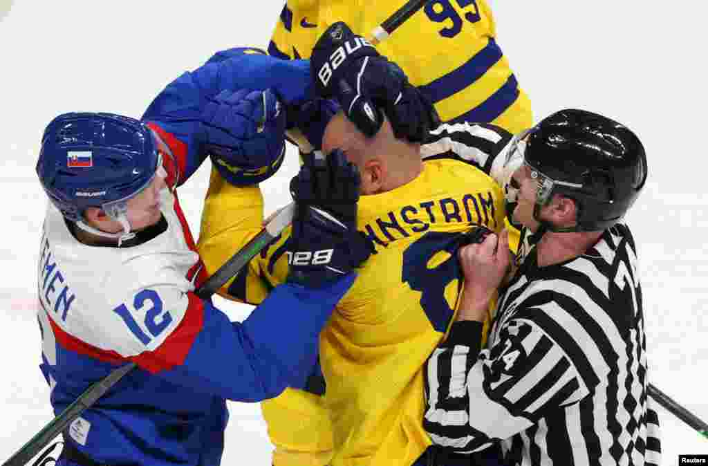Milos Kelemen of Slovakia and Theodor Lennstrom of Sweden clash during a men's ice hockey game at the 2022 Beijing Olympics, Wukesong Sports Centre, Beijing, China.