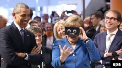 Prezidan Obama ak Chanselye Merkel pandan yo tap vizite fwar sou teknoloji endistriyèl la nan vil Hanòv.